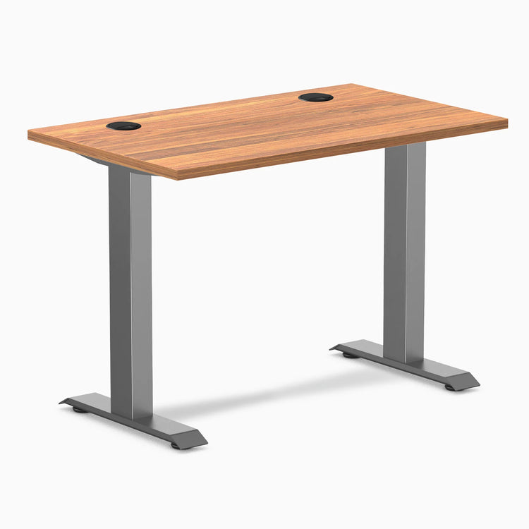 Desky Zero Mini sit-stand desk with Prime Oak top, Space Gray fixed legs, and two grommets.