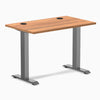Desky Zero Mini sit-stand desk with Prime Oak top, Space Gray fixed legs, and two grommets.