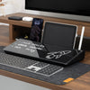 Black glass Desky Desktop Whiteboard with storage, holding a phone, tablet, and stylus on a wooden desk.