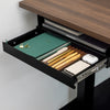 Black Desky Ultra Slim Under Desk Drawer, open and filled with pens, notebooks, and tech accessories.
