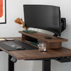 Desky Heavy Duty Ultrawide Monitor Arm holding a large curved monitor on a dark wood desk.