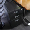 Desky 3 Drawer Mobile Filing Cabinet in black powder-coated steel with rounded edges, sitting under a wooden desk.