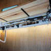 White Desky Integrated Cable & Power Channel with power outlets, neatly organizing cables under a light wood desk.
