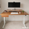 White ash hardwood standing desk with a matching drawer, white legs, and monitor riser.