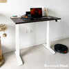 Desky Dual Mini sit-stand desk with burnished wood top and white frame, set up with a laptop.