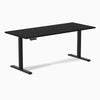 Black Desky Single Sit Stand Desk, 70.9 x 29.5 inches, with grommets and height-adjustable frame.