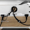 Black Desky braided polyester cable organizer sleeves tidying multiple cables under a white desk.