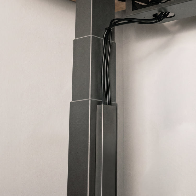 Black Desky magnetic cable management attached to desky frame legs 
