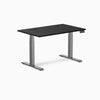 Desky Dual laminate sit-stand desk with black 47.2x29.5 inch top, grommets, and space gray frame.