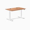 Desky Dual Sit Stand Desk with Prime Oak laminate top, white frame, and two black grommets.
