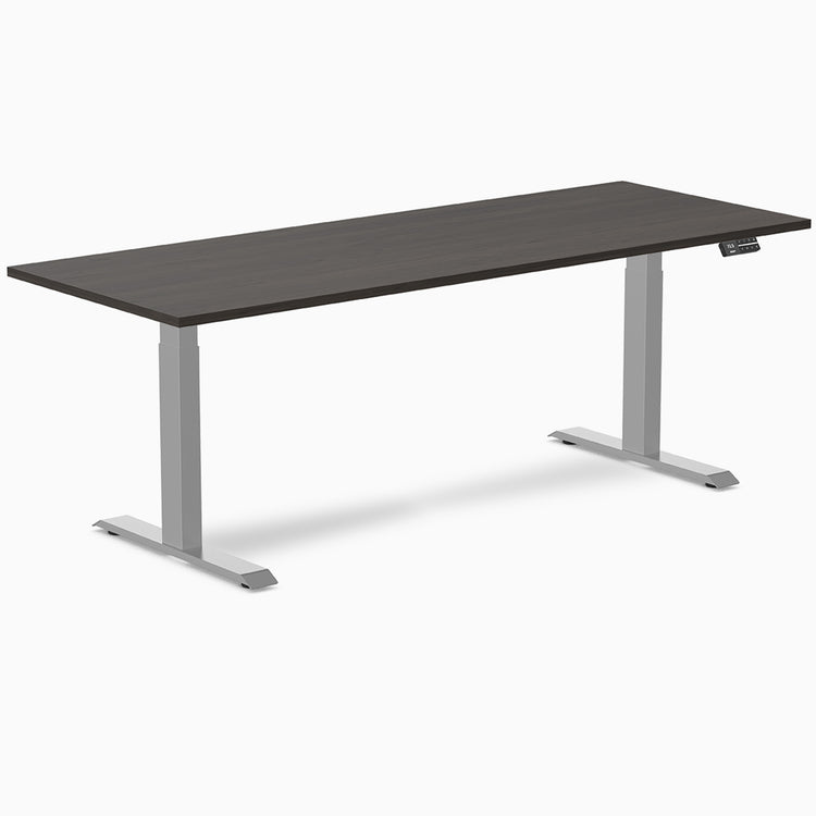 Desky Dual Laminate Sit Stand Desk with dark woodgrain top and silver adjustable legs.