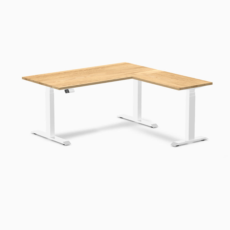 White oak L-shape sit-stand desk with white frame and digital control panel.