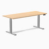 Desky Dual custom laminate sit-stand desk with a light wood top and silver adjustable legs.