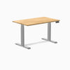 Desky Dual 48x30 inch White Oak hardwood sit-stand desk with gray legs and control panel.