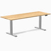 Desky Dual 80x30 inch White Oak hardwood sit-stand desk with gray legs and control panel.