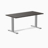 Desky Zero laminate office desk with a dark wood-grain top and silver steel I-frame legs.