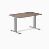 Desky Zero fixed-height office desk with a dark wood laminate top and silver steel frame.