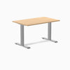 Desky Zero laminate office desk with a light wood top and silver steel frame.