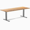 Desky Zero Teak hardwood office desk, 80x30 inches, with a space gray steel frame.