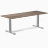 Desky Zero fixed height office desk with a dark wood laminate top and silver steel frame.